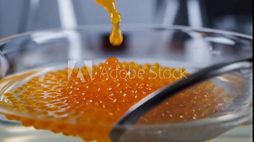 Macro POV of spherification process creating vibrant fruit juice caviar spheres using pipette, molecular gastronomy science experiment.
