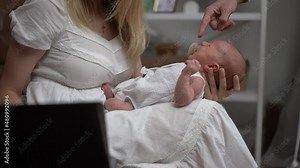 Crying little baby spit out pacifier lying on laps of busy mother freelancer working online. Adorable newborn infant dissatisfied with lack of attention and unrecognizable Caucasian woman at home