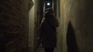 Woman running in narrow street at night