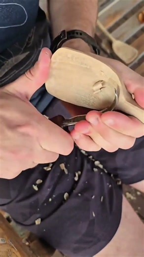 carving the wooden spoon bowl using a sharp metal hooked carving tool