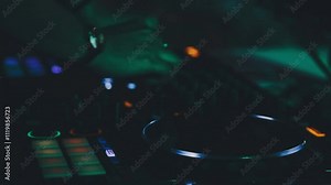 DJ work in a nightclub, mixing. A club DJ mixes music using an audio mixer and turntables on stage. A disc jockey plays in a club at a party.