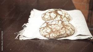 Male Baker in apron gets out of the oven two loaves of bread