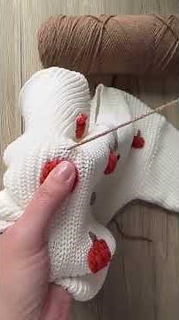 Woman shows how to stitch pumpkins onto a sweater using chunky yarn!