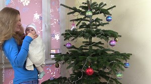 Happy mother mom kiss cute newborn baby and sway in hands near Christmas tree. Static shot on Canon XA25. Full HD 1080p. Progressive scan 25fps. Tripod. Stock Video