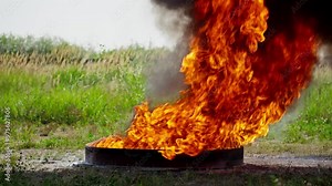 Flames erupt from manhole cover, creating striking contrast against lush green surroundings. Moment captures unexpected burst of fire in nature. Slow motion in 4K, UHD Stock Video