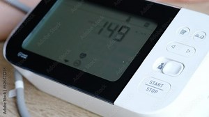 Man checks blood pressure monitor and heart rate monitor with digital pressure gauge. Health care and Medical concept.