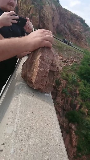 Throwing rock off dam | People Throwing Rocks
