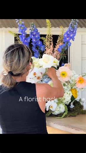 Santa Barbara Wedding Florist • Mackenzie Nancarrow Designs on Instagram: "A florist hack - A saddle, a piece of wet foam, chicken wire, and slow layers. That’s how I build bar arrangements that feel sculptural and effortless Bar recipe 10 stems hydrangea 3 stems purple hybrid delphinium 5 mixed color poppies 1 bunch white dahlia 1 bunch peach stock 1 bunch hanging green Amaranthus 5 stems white delphium 5 stems Eremurus 11 playa Blanca roses 3 stems orchid - put in last to cascade Mechanics Sad