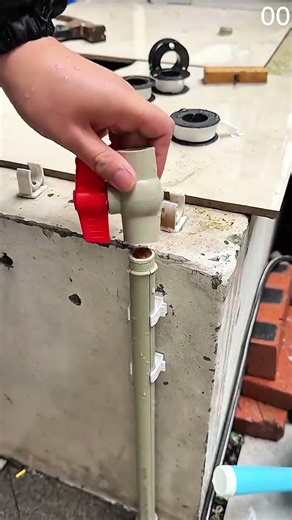 Red valve tops vertical pipe near thread tape.