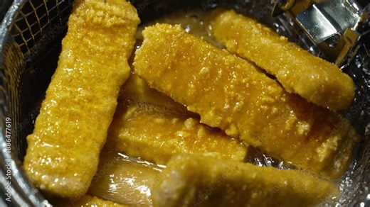 fish sticks cooking into heated vegetable oil in a deep fryer. cooking in hot oil.
