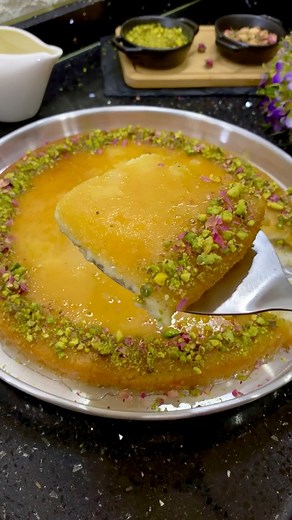 كنافه التوست ( الكنافه الكذابة) استخدمت كيس واحد من التوست 💫مقادير القشطه٢ كوب حليب ٢ ملعقه كبيره نشا٤ حبات جبنه كريميةربع كوب مبشور موزريلا نصف ملعقه كبيره ماء الورد( ممكن نستغني عنه)علبة قشطه 💫مقادير الشيره ٢ كوب سكر ٣كوب ماء عصره ليمون قليل من الزعفران تركتهم يغلوا على النار مده عشر دقايق وبعدها تركته يبرد | منى الحسون