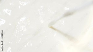 Super slow motion of pouring steamed fresh milk into a glass, frothed milk, mixed milk, close-up.