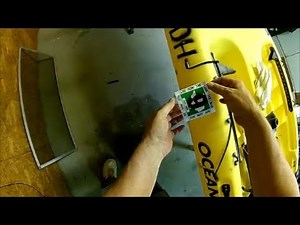 Installing a (trolling motor) registration sticker on a kayak.
