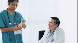 Senior asian man medical doctor sitting on his desk, talking to young medical woman doctor examine bone mock up. Young medical doctor career concept.