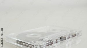 Vintage analogue compact audio cassette 4K 2160p 30fps UltraHD tilting footage - Transparent magnetic tape on white background slow tilt 3840X2160 UHD video