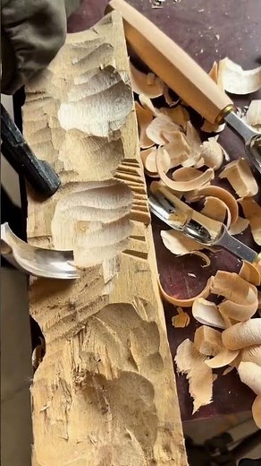 traditional hand carving process of wood using sharp gouge tools to create intricate textures