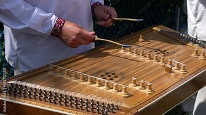 Playing the dulcimer folk musical instrument from Europe, playing the cymbals, cymbal, a young man playing cymbals, dulcimer musical instrument