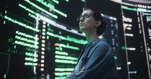 Portrait of Young Woman Looking at Big Digital Screens Glitching While Displaying Code Lines. Worried Professional Programmer Trying to Fix a Bug, Dealing with Crashing System, Thinking of Solutions