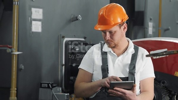 An engineer uses a computer tablet to inspect gas equipment.