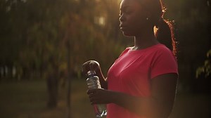 Water refreshment. Healthy lifestyle. Aqua detox. Profile portrait of thirsty drinking woman in defocused copy space summer park lens flare landscape.