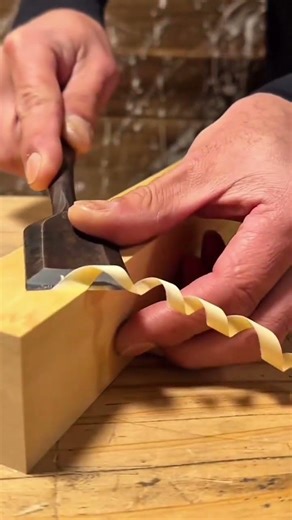 Shaping a long wooden board with a sharp chisel to get a flat and even surface finish