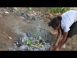cooking laplap on an earth oven with hot rocks