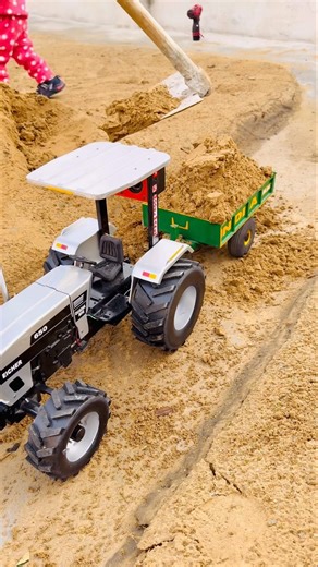 Rc tractor pulling full loaded trolley with soil