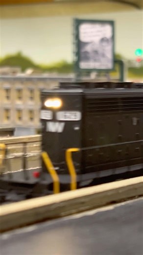 Model train club layout with NW passing by