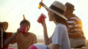 Happy friends group partying on the beach and cheers alcohol drinks on summer sunset. Group people having fun and enjoy beach party drinking beer. Summer vacation concept.