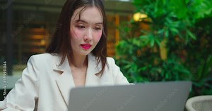 Beautiful korean woman using computer in restaurant. Female manager writing information e learning distance education restaurant outdoor terrace.