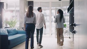 Attractive Couple with real estate agent visiting house for sale or for rent. Buying an apartment. Feel happy smiling at sunlight modern room. Realtor client.