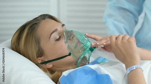 Hospital nurse helping sick woman to put on oxygen mask, respiratory disorder