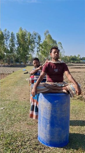 The boy is sitting on the drum.