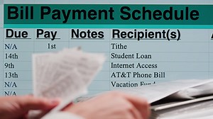 Hands Organizing Receipts with a Bill Payment Schedule on Screen | Premium Stock Video Footage