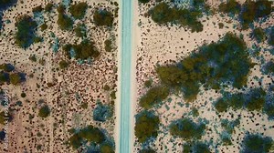 Australian desert with dirt path at sunset, Western Australia. Aerial backward top-down view