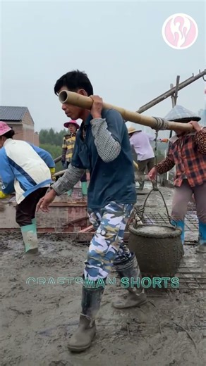 Cement | Two people carrying a bucket of cement