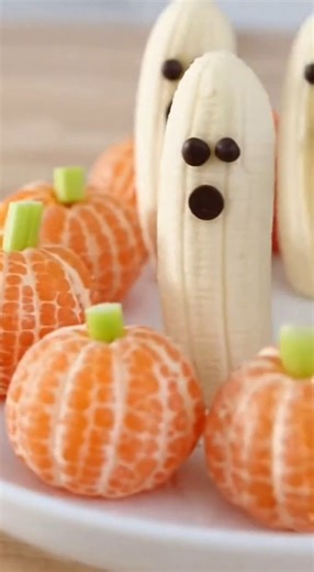 Who says Halloween treats have to be all candy? Watch me transform everyday fruits into the most adorable spooky snacks in seconds! Banana halves become floating ghosts with just three chocolate chips, while mandarin orange segments turn into perfect little pumpkins with celery stick stems. These treats are so cute, kids won't even realize they're eating healthy! Perfect for school parties, afternoon snacks, or when you need a break from all that Halloween sugar. Takes literally 2 minutes to mak