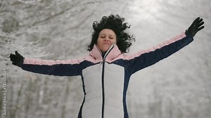 Jogger running in the snowy forest celebrating success with wide open hgands, slow motion