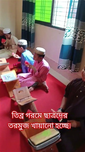তিব্র গরমে ছাত্রদের তরমুজ খায়ানো হচ্ছে।