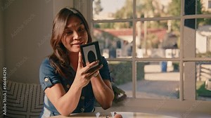 woman puts on lipstick in home