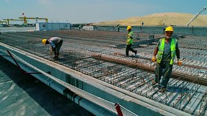 Workers Assembling Steel Grid at Construction Site