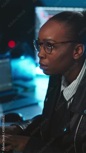 Hacker, woman and glasses in basement with computer, cyber attack and doubt spyware for network breach. Black person, programming and typing with desktop, AI software and concern for hacking system.