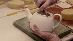 After being cast in moulds, our 1770 Italian teapots are fettled. By hand, the rough seams and edges, left on the clay piece by the mould, are carefully trimmed. Leaving a smooth teapot body ready for glazing. | Spode