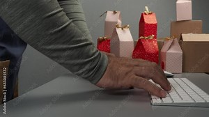 The packer in the warehouse sends a gift to the buyer through the online store. E-commerce, delivery of goods, color boxes for gifts.