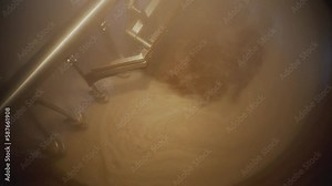 Huge steel brewing tank close-up.Beer in a whirlpool, mixed. Equipment at the brewery. Technological process of brewing.