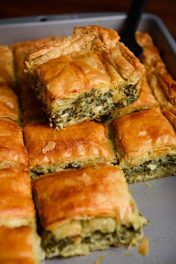 A golden, flaky Puff Pastry Spanakopita, filled with a creamy blend of fresh spinach, spring onions, silky milk-and-flour custard, eggs, and tangy feta. The pastry puffs into crisp layers while the inside stays soft, savory, and gently aromatic—a comforting, modern twist on the classic Greek spinach pie. Full recipe here: https://realgreekrecipes.com/puff-pastry-spinach-and-feta-pie/ | Real Greek Recipes