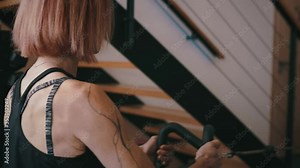 Adult female performs cable row exercise in gym, close-up