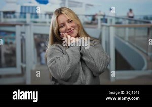 Young blonde woman smiling on cruise ship deck with casual attire, enjoying outdoor seaside view on a sunny day, embracing freedom and adventure aboard the luxurious boat Stock Video Footage - Alamy
