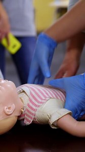 Newborn resuscitation on an infant dummy doll. First help medical class. Healthcare and education. Vertical