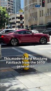 Ford Mustang Fastback from the S650 generation wears a striking dark metallic red-magenta finish